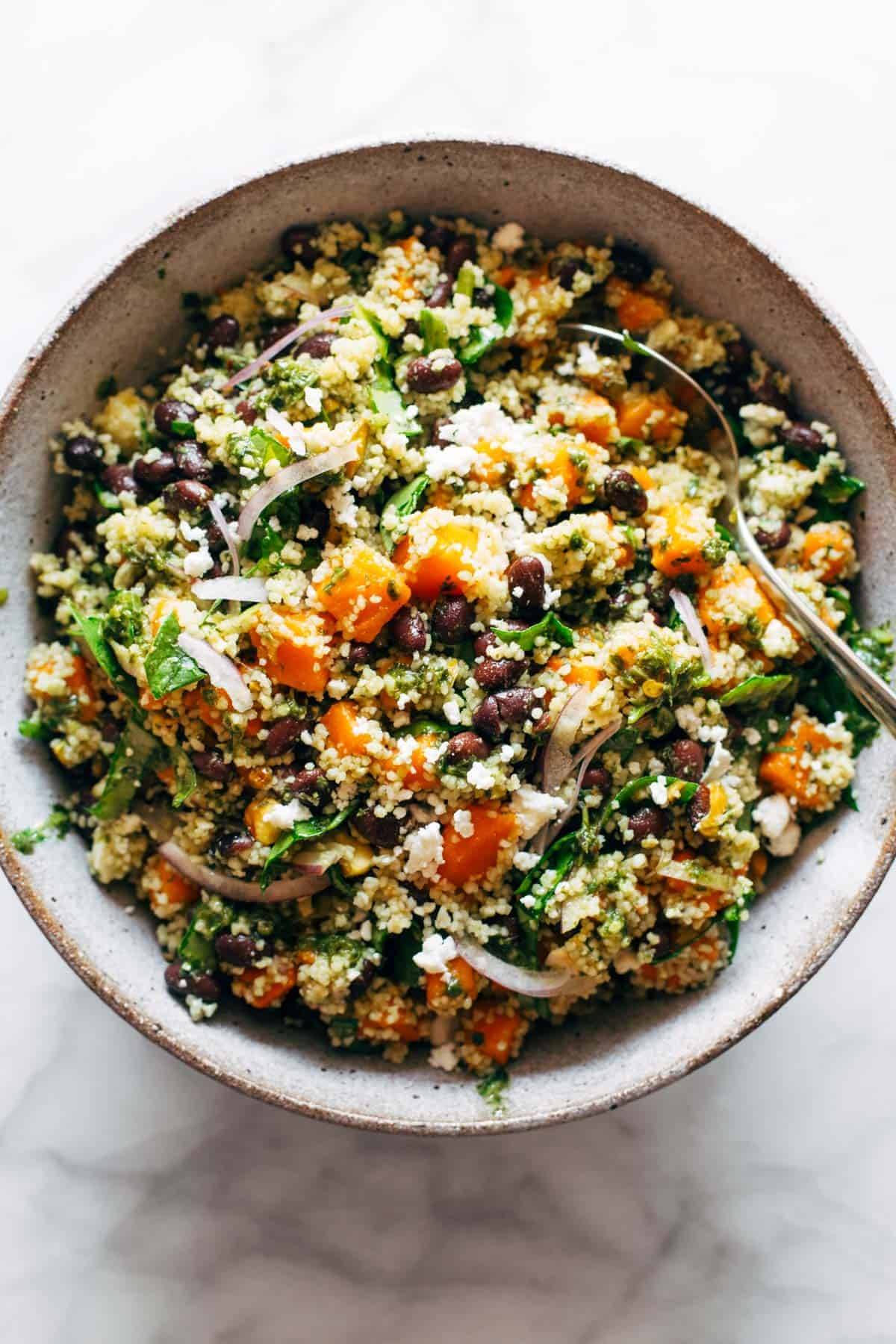 Couscous salad in a bowl with sweet potatoes and black beans.