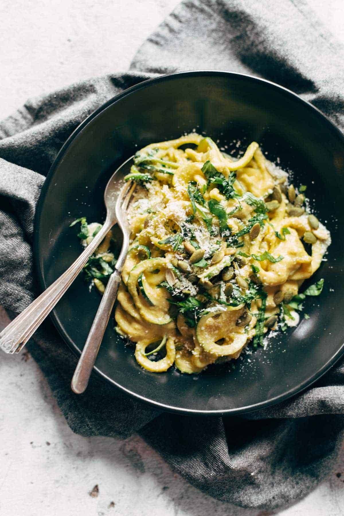 Zoodles with Creamy Corn Sauce in a bowl with a spoon and a fork.