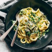 Creamy Corn Zoodles in a bowl with fork and spoon.