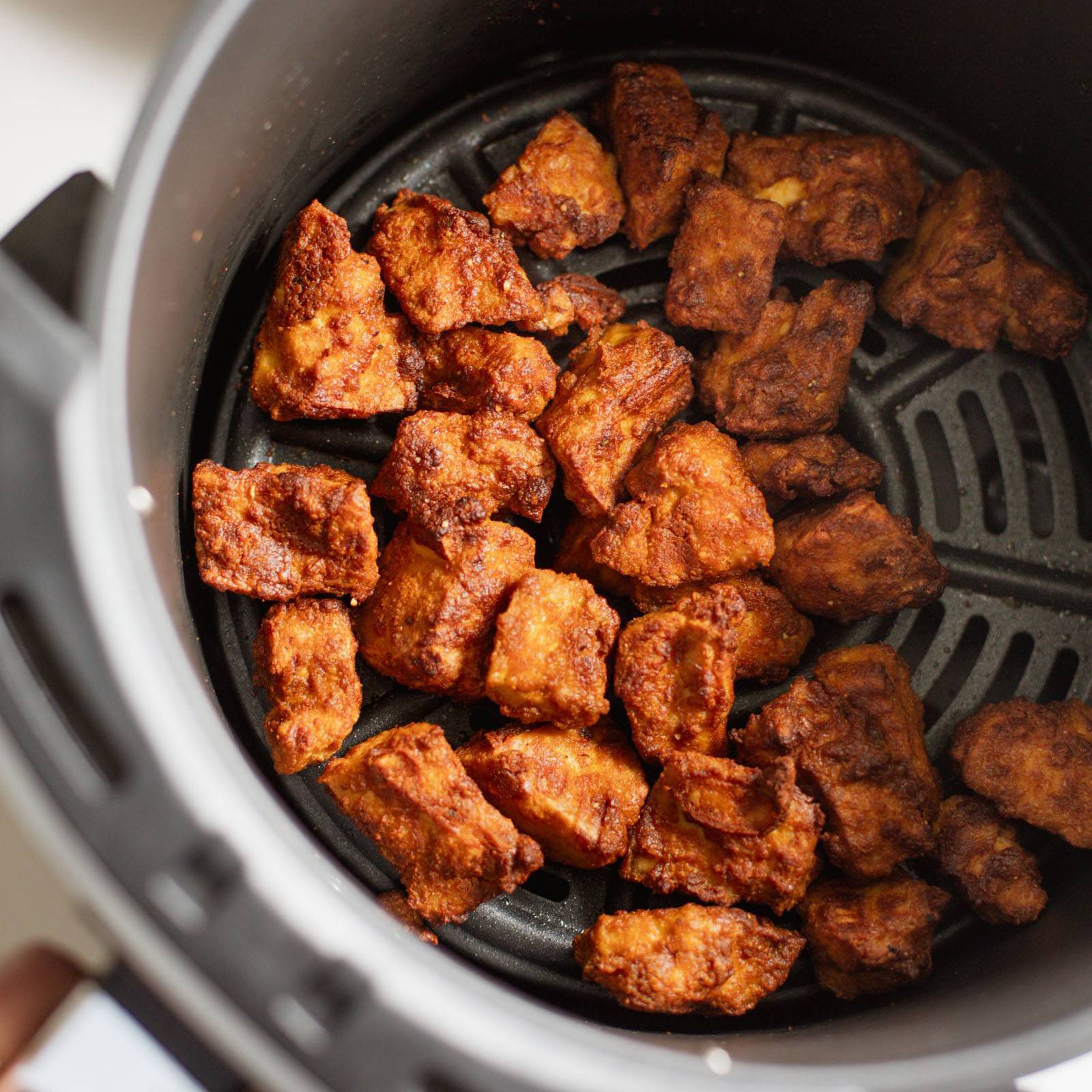 Air fryer tofu in an air fryer basket.