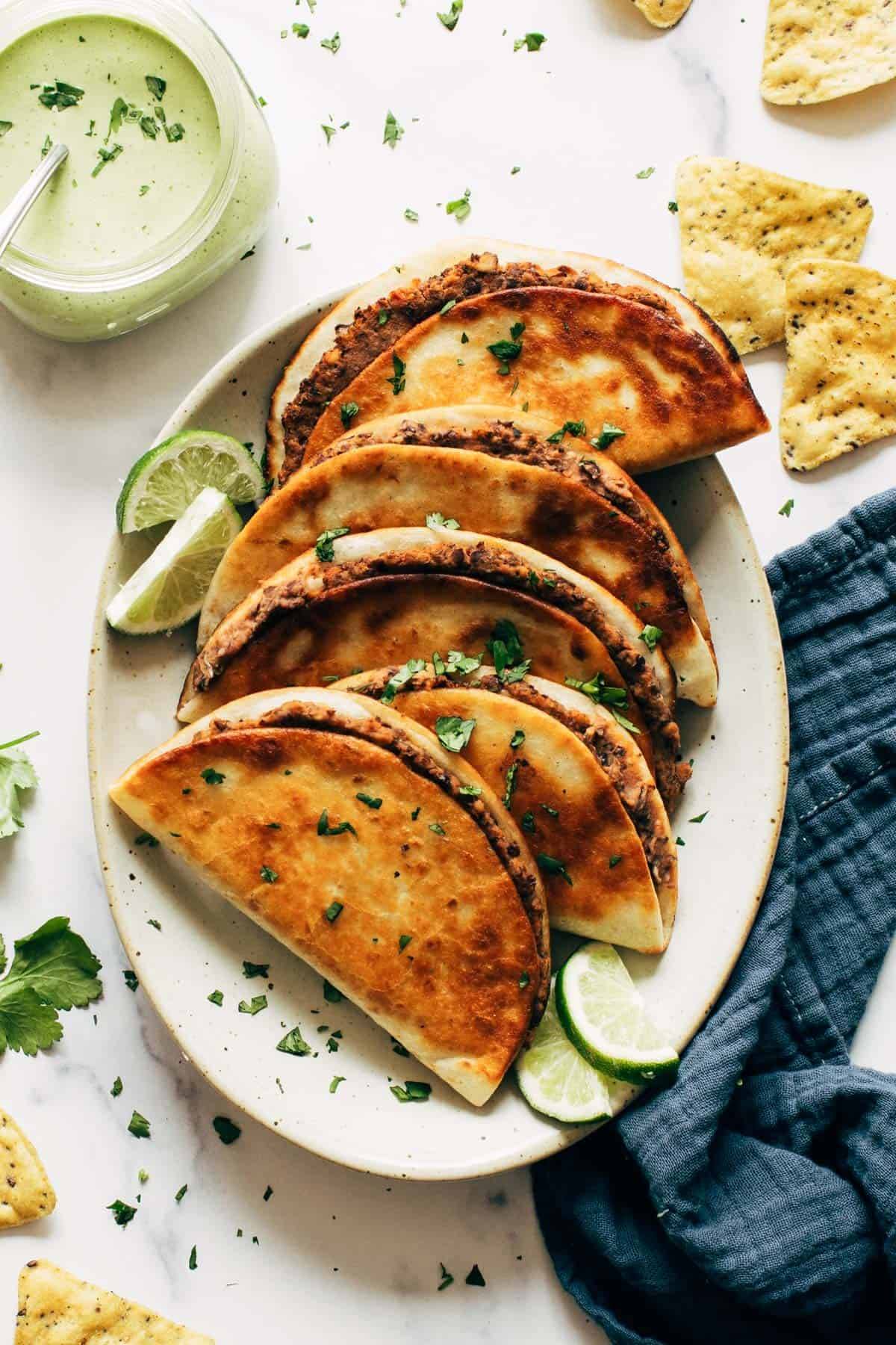 Crispy Black Bean Tacos on a platter with limes