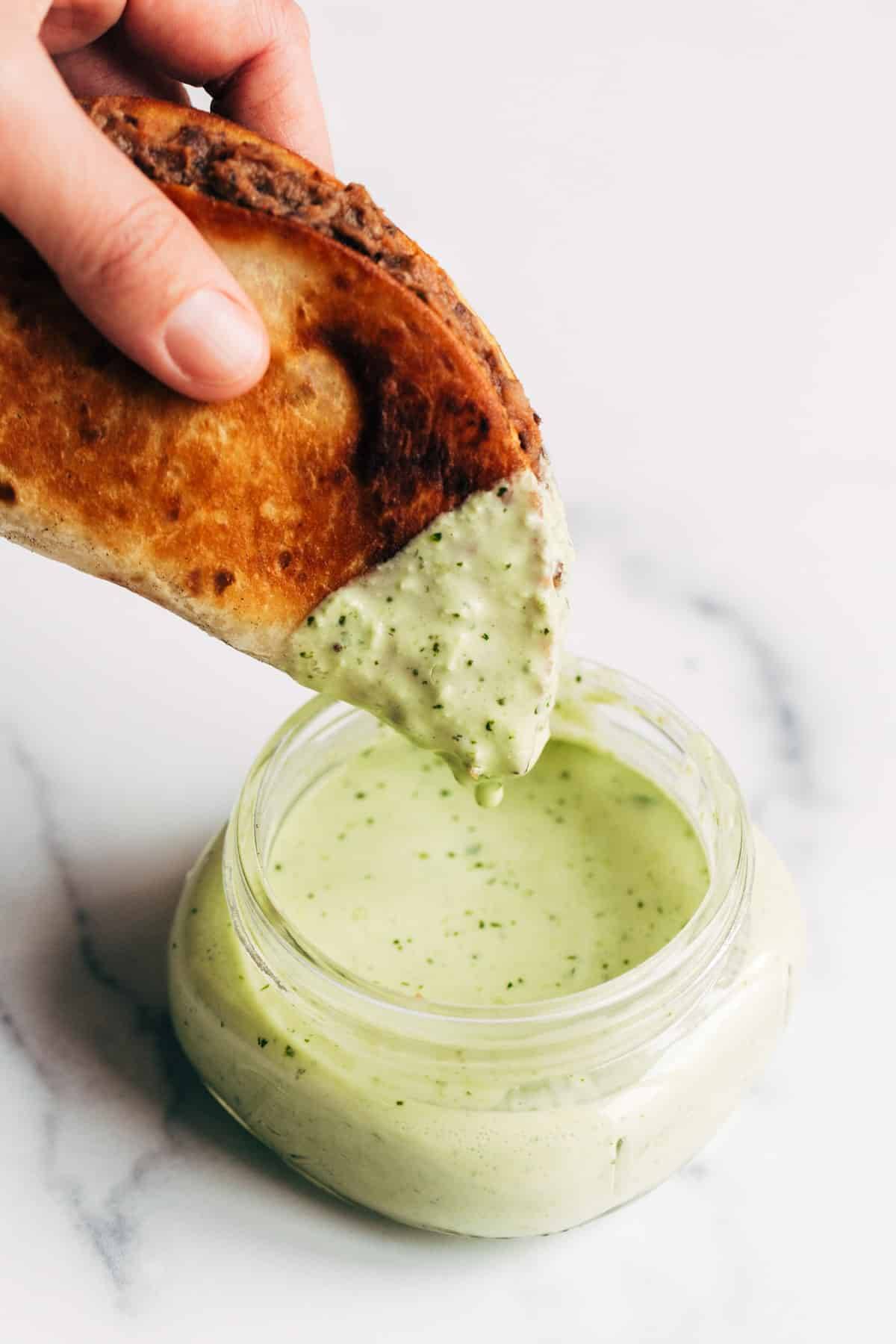 Crispy Black Bean Taco being dunked into Cilantro Lime Sauce