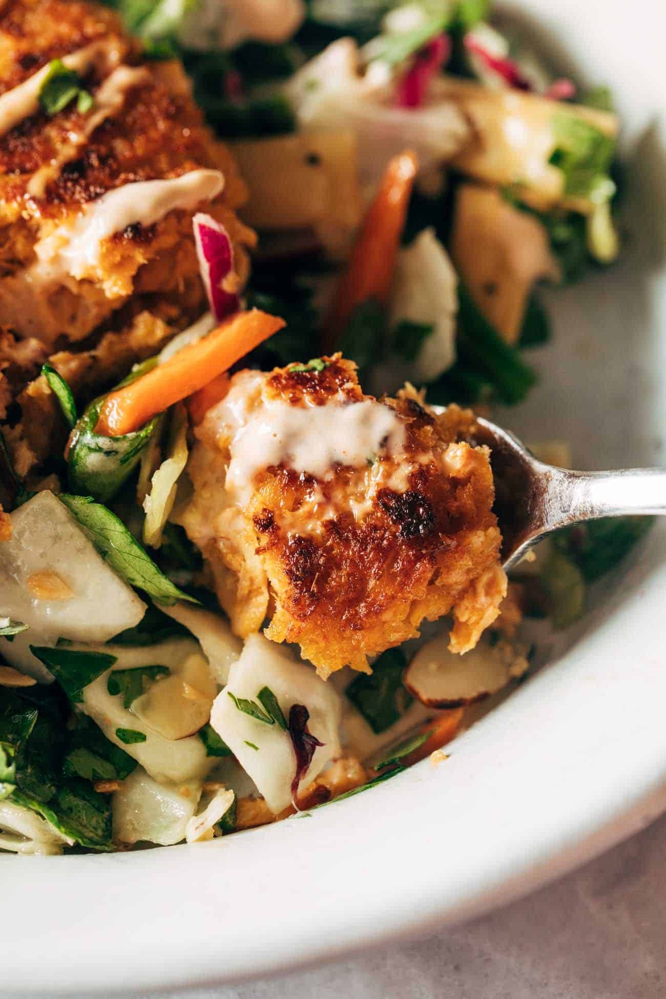 Salmon burgers being scooped up with fork