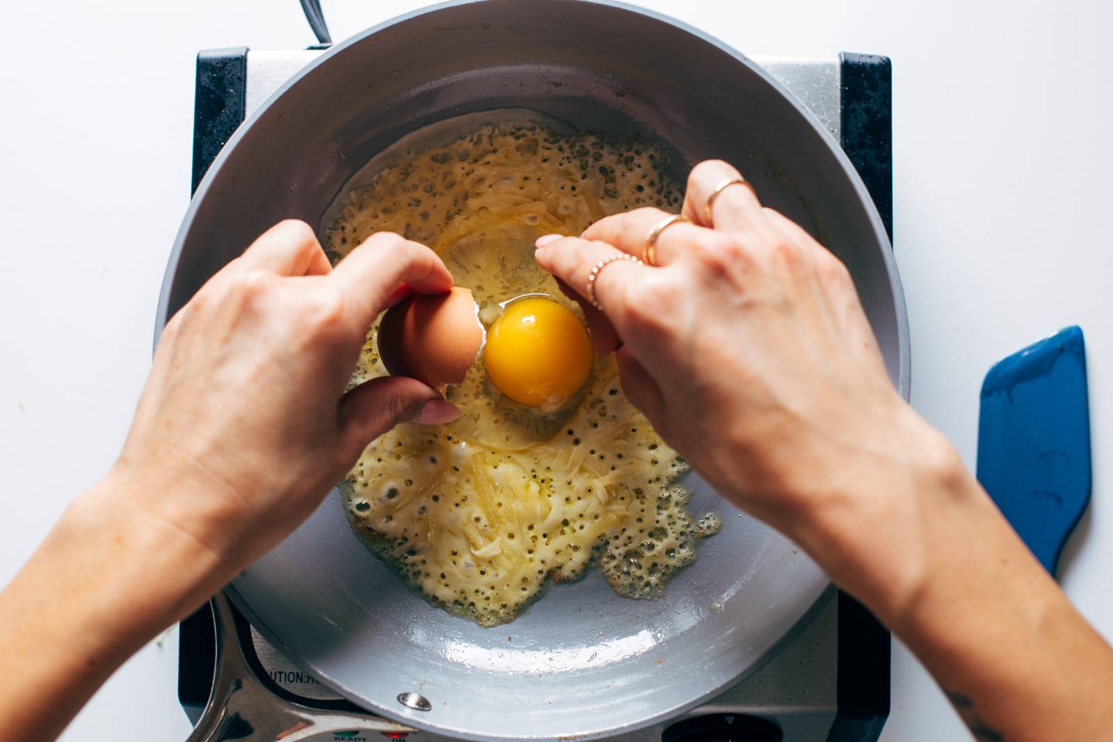 Egg cracked into the cheese skirt.