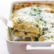 Enchiladas Verdes in pan with spatula.