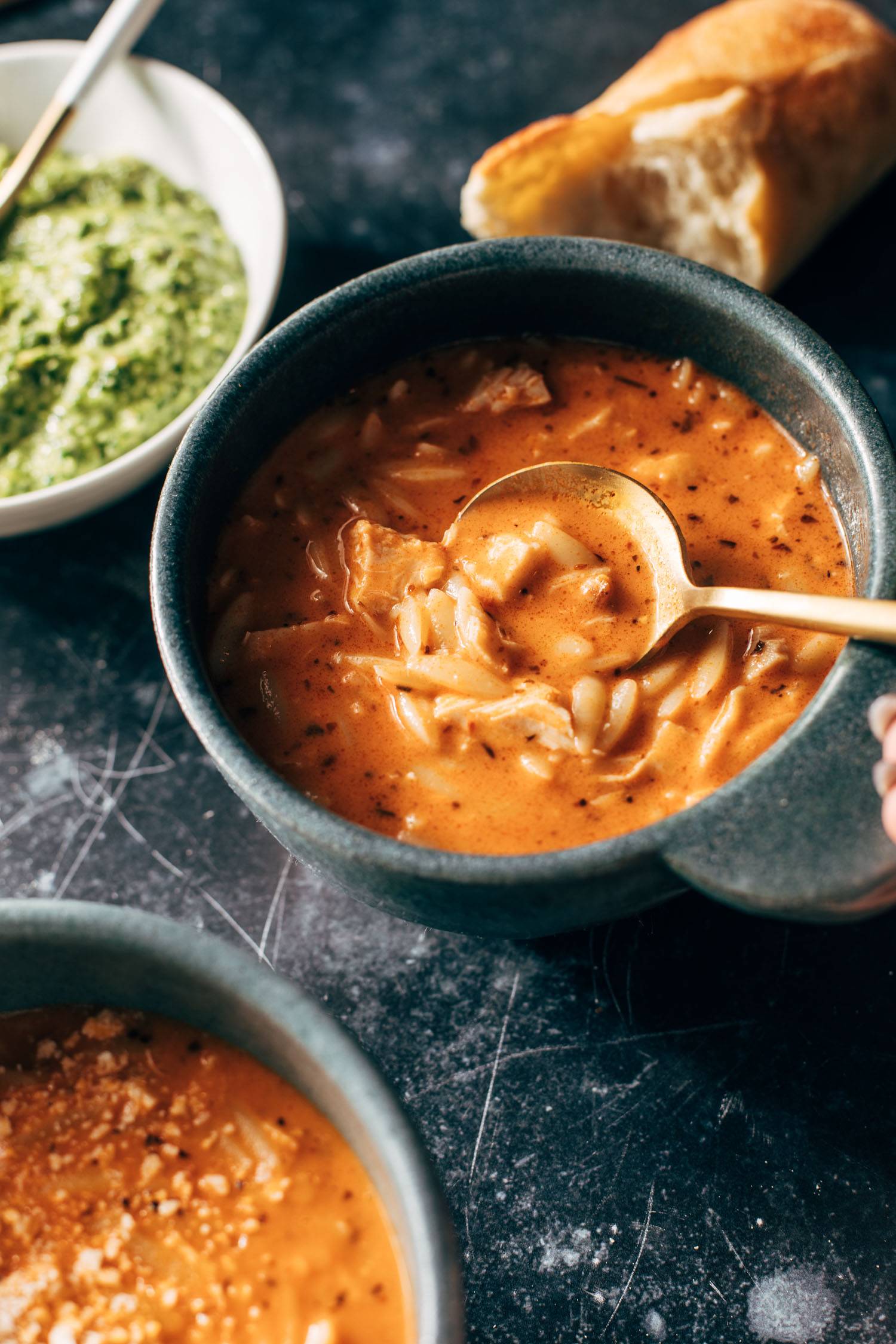 Chicken orzo soup in a bowl with a spoon