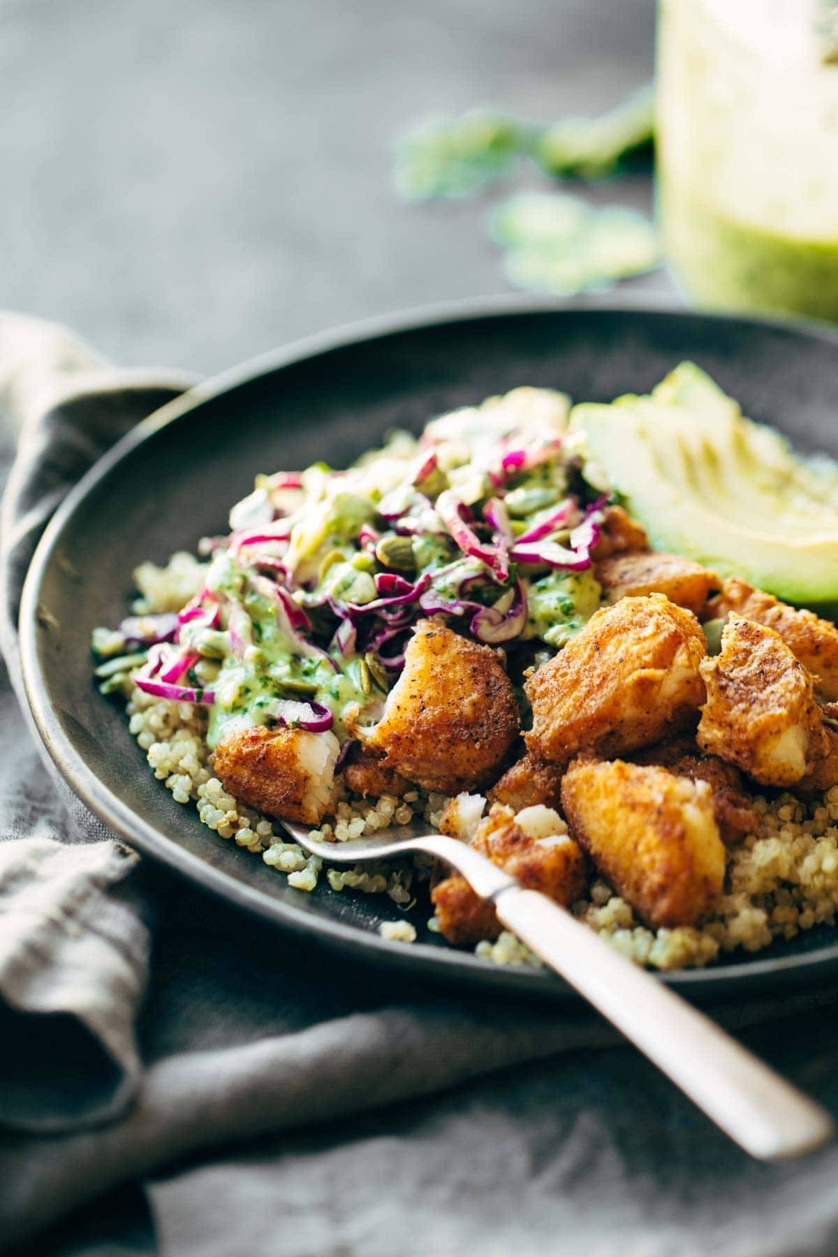 fish taco bowls with cilantro lime slaw on a plate with a fork