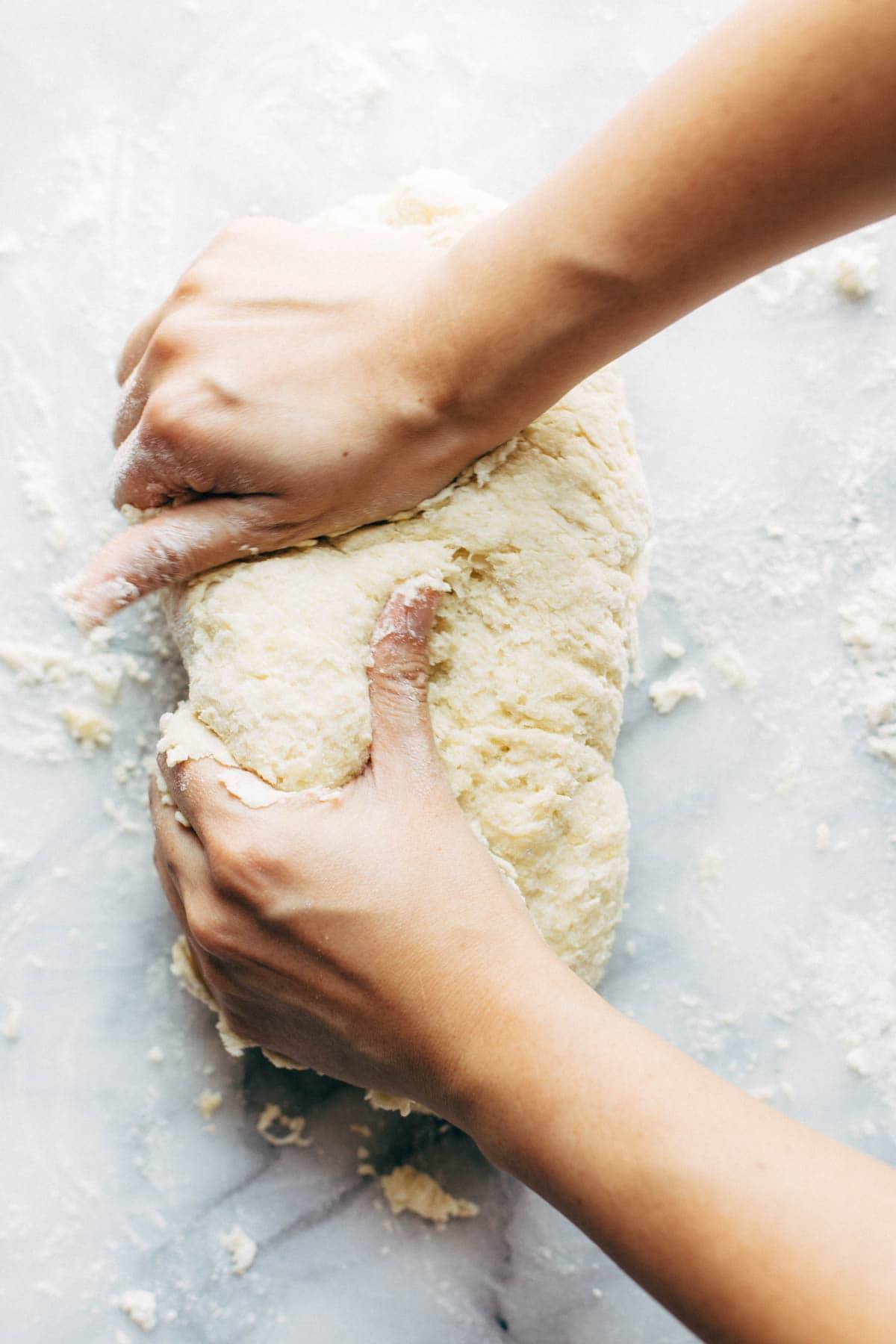 Hands kneading gnocchi dough.