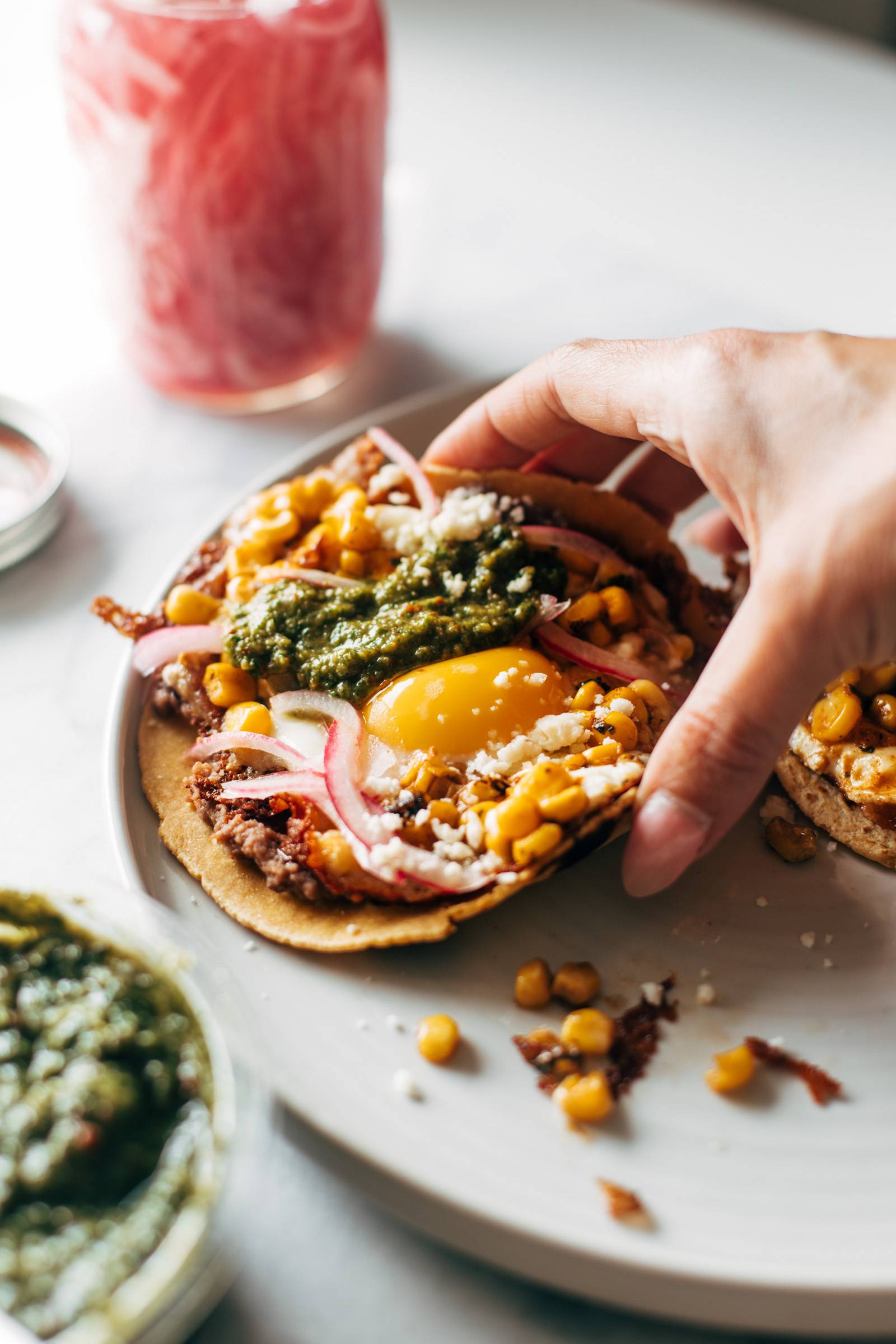 Hand picking up a fried egg taco.