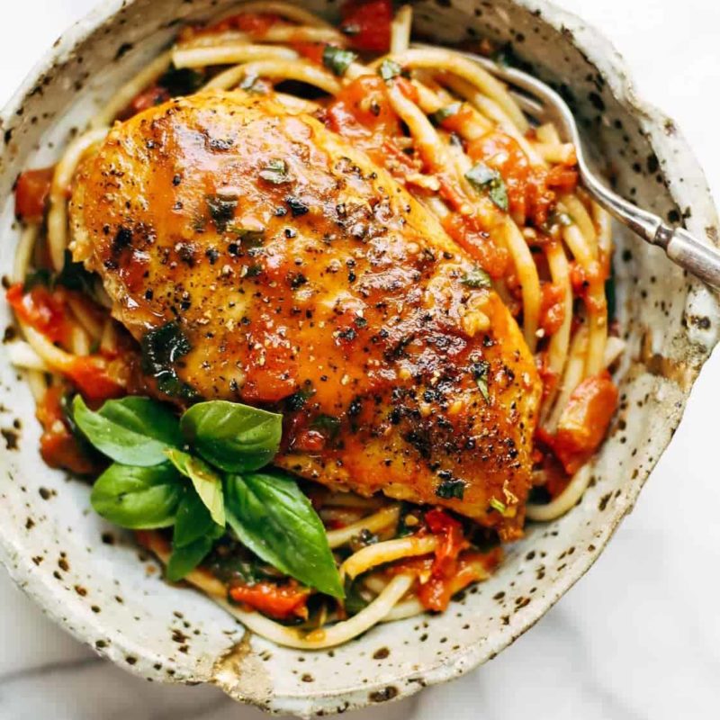 Garlic Basil Chicken in a bowl with pasta and basil.