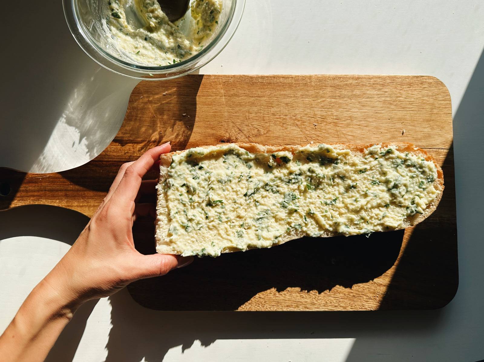 Butter mixture spread across half a loaf of bread.