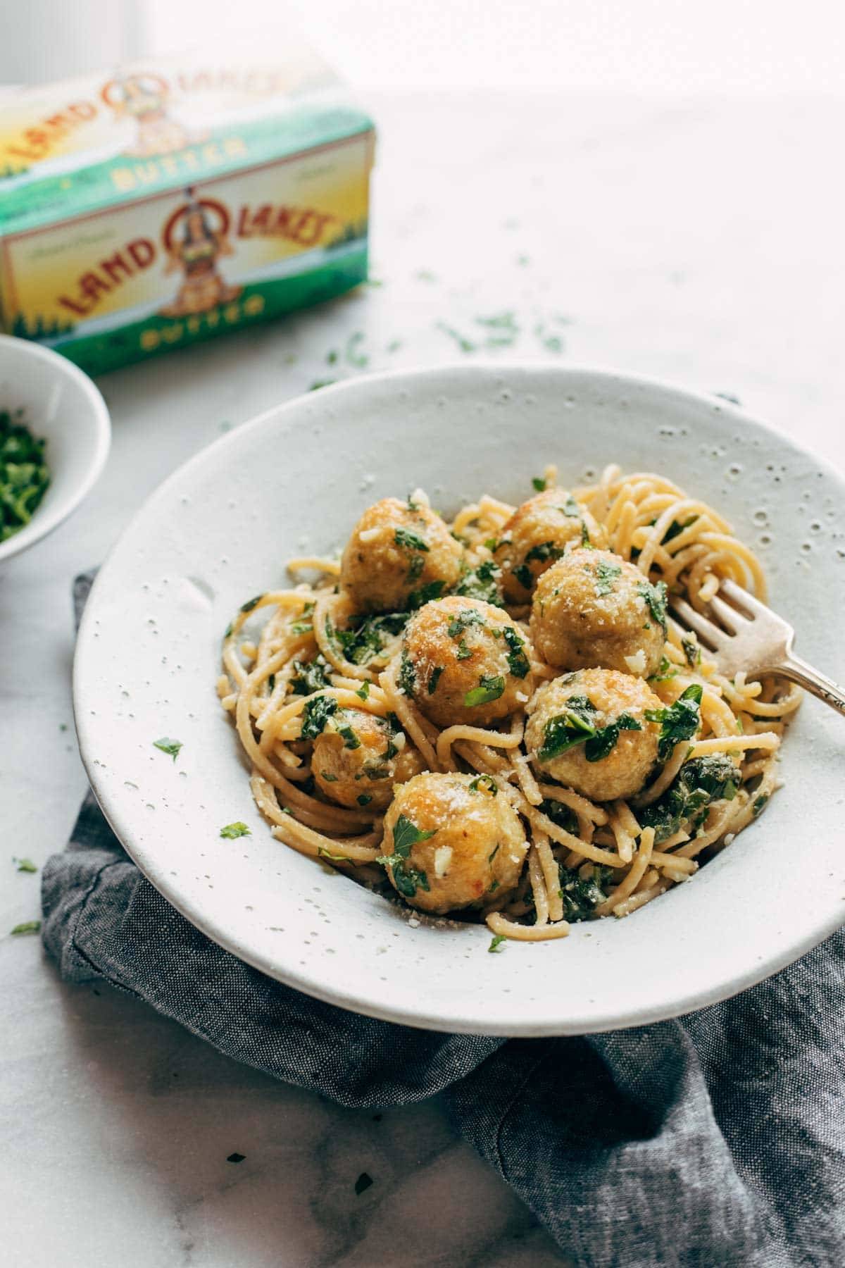 Garlic Herb Spaghetti with Baked Chicken Meatballs in a bowl with fork twirl.