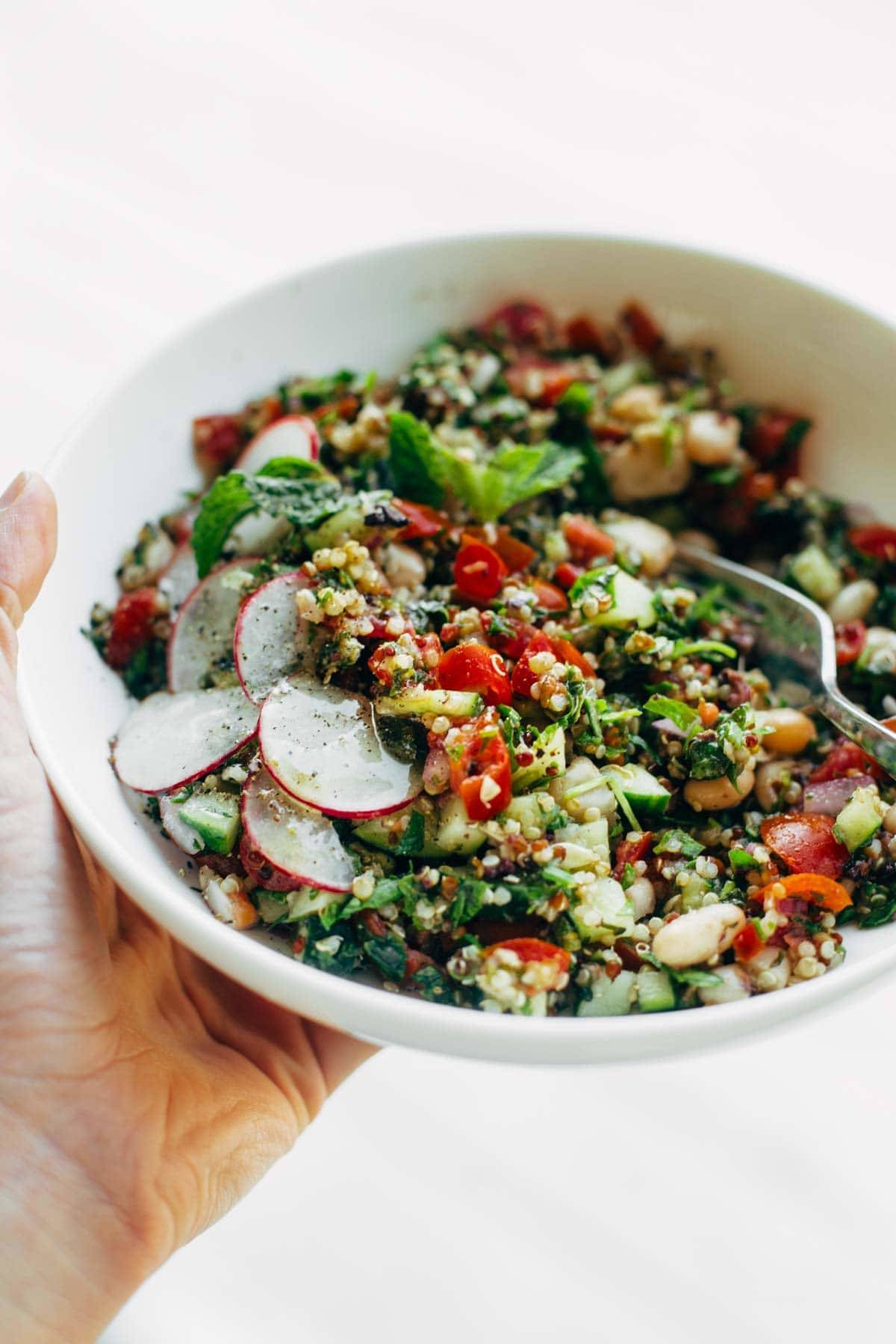 Greek salad with a fork in a bowl.