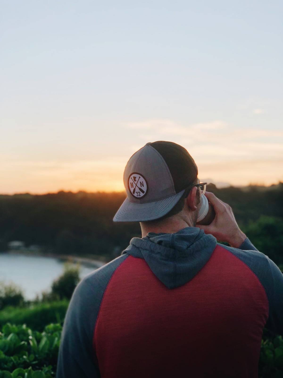 Man wearing a hat drinking coffee.