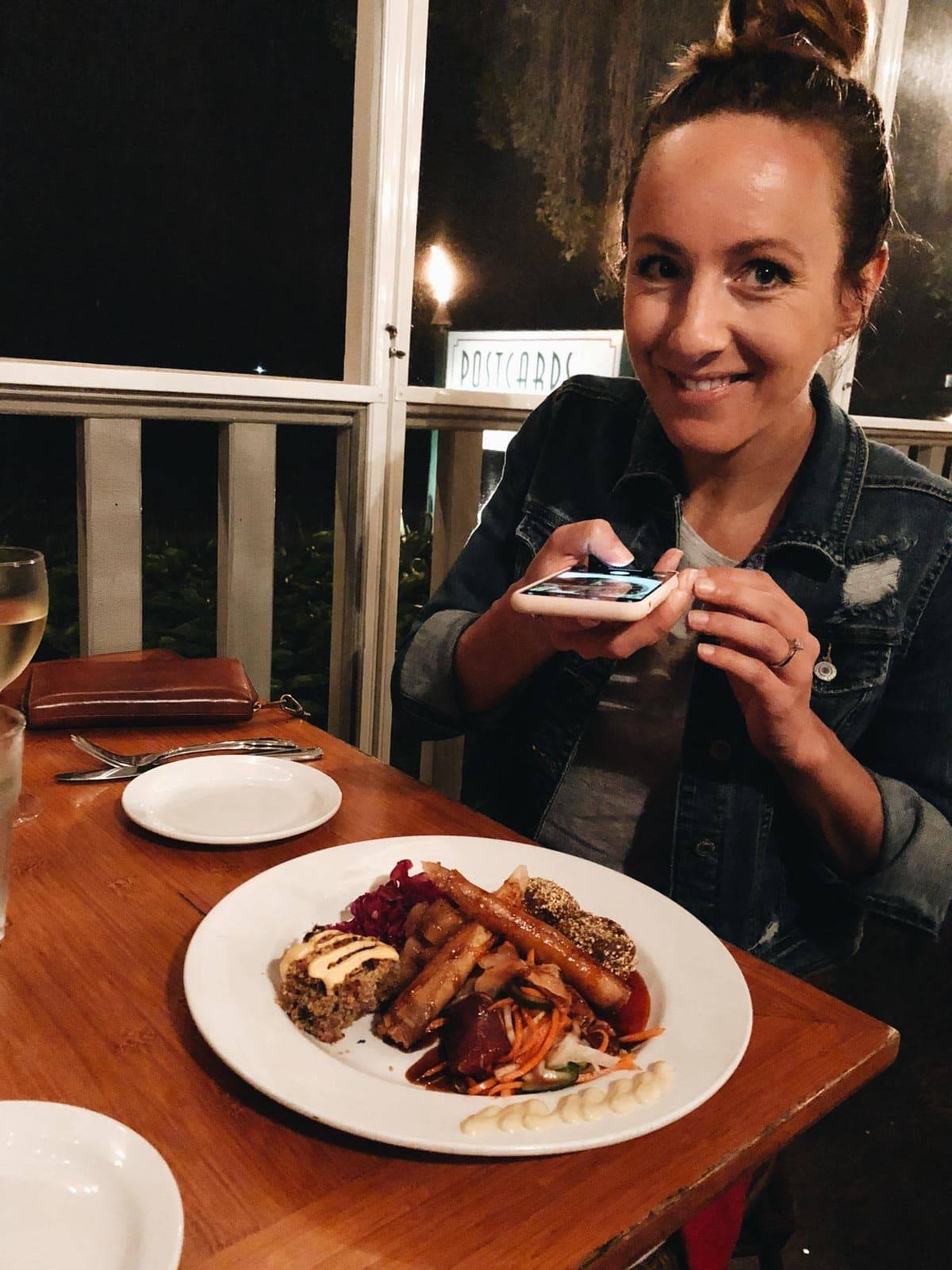 Woman taking a photo of food on her iphone.