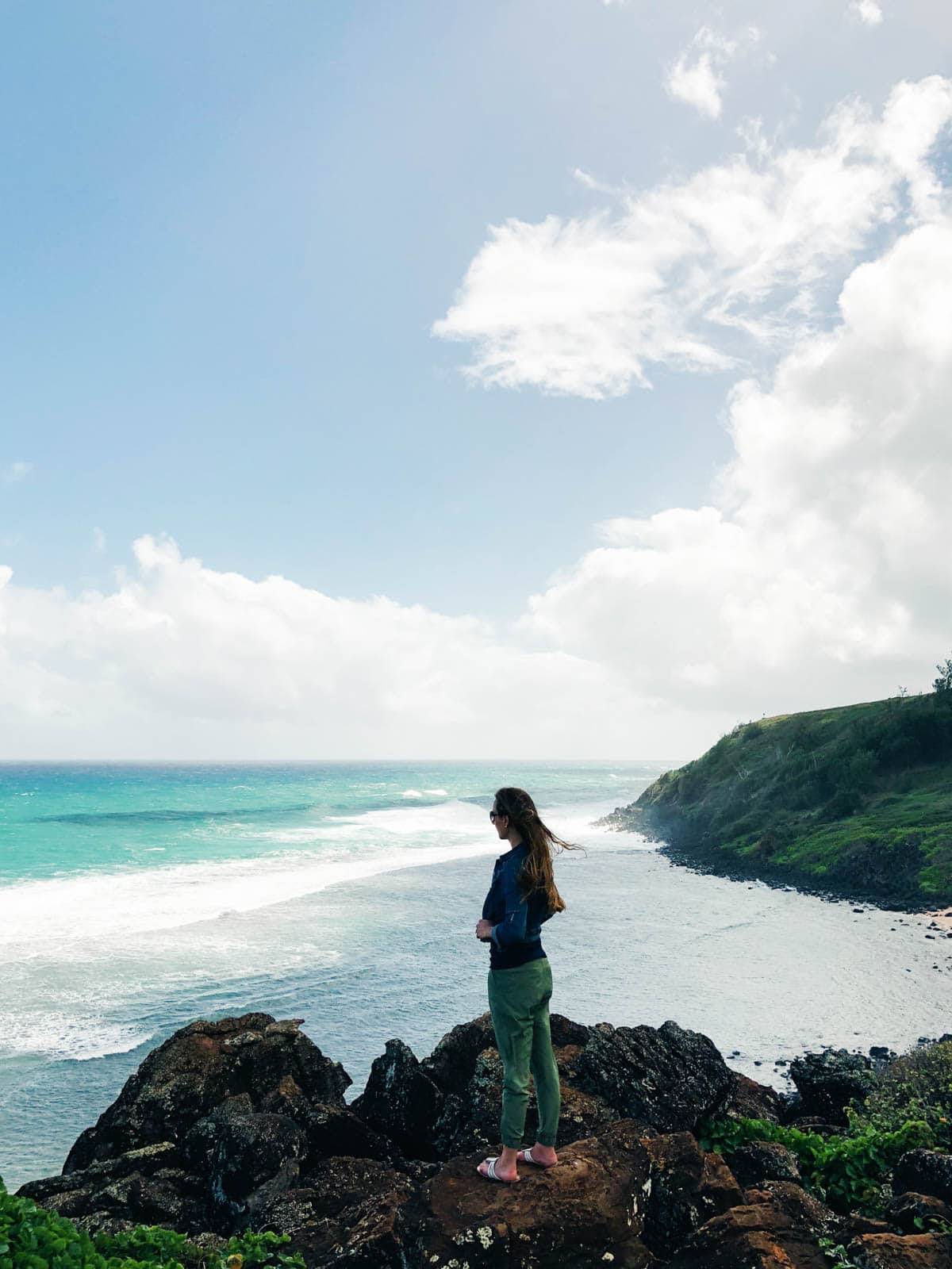 Woman standing on rocks on the beach.