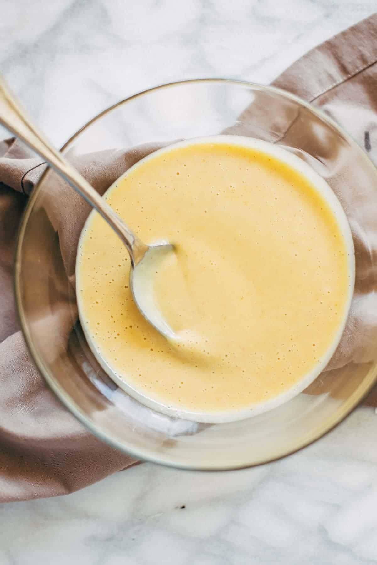 Honey mustard sauce in a bowl with a spoon. 