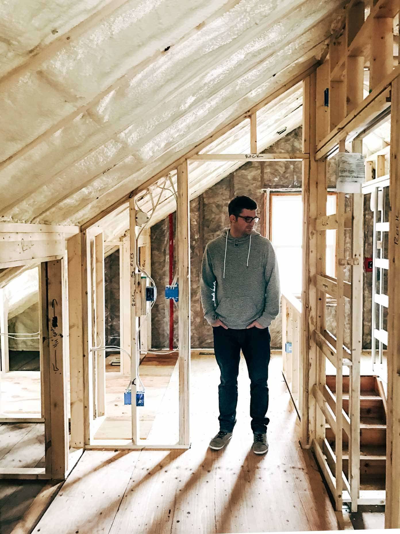 A man standing in a doorway in an unfinished building.