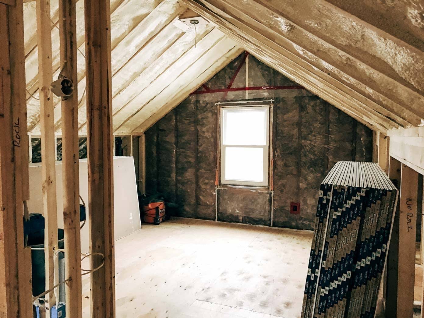 A house with the window and bed and a bean bag in the corner.