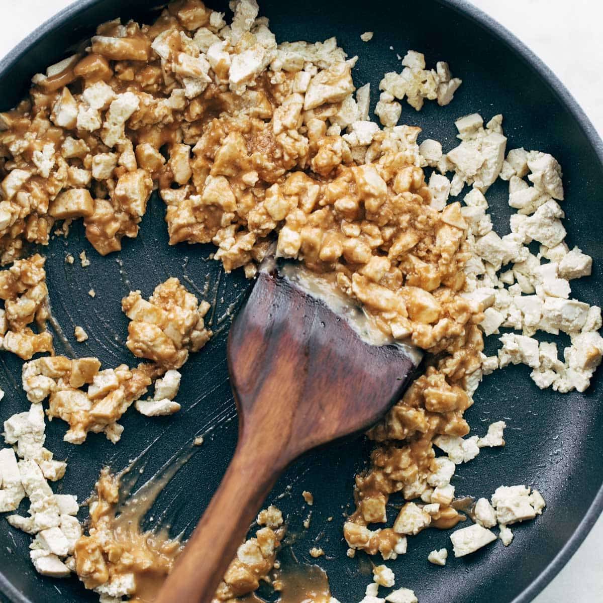 Scrambling tofu in a pan.