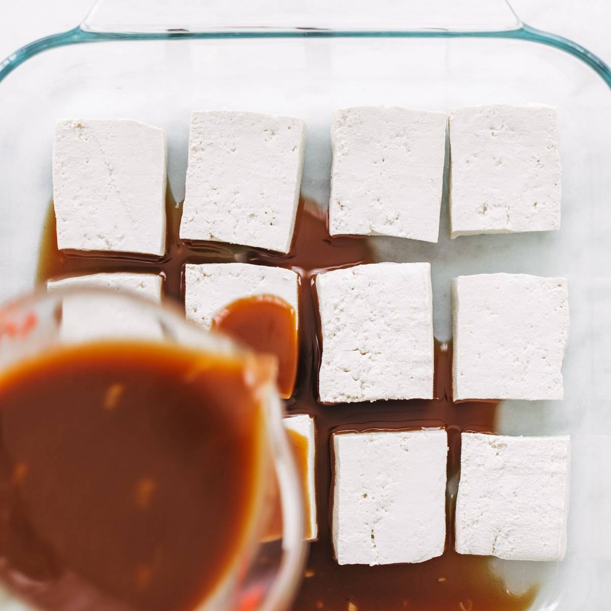 Tofu in baking pan with sauce.