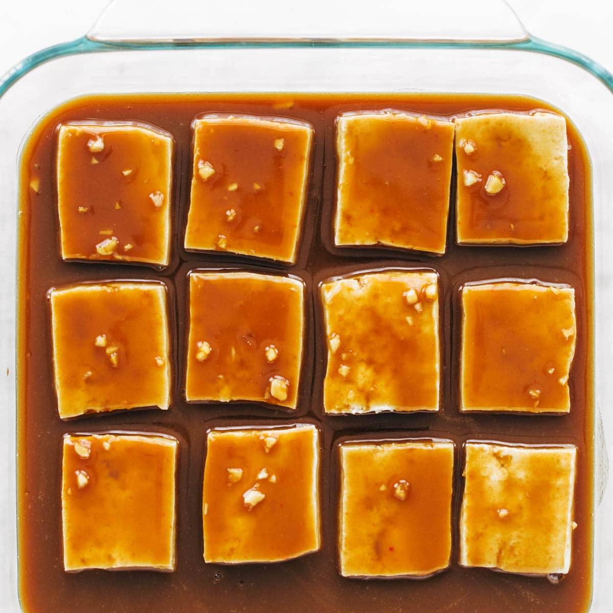 Tofu in baking pan with sauce.