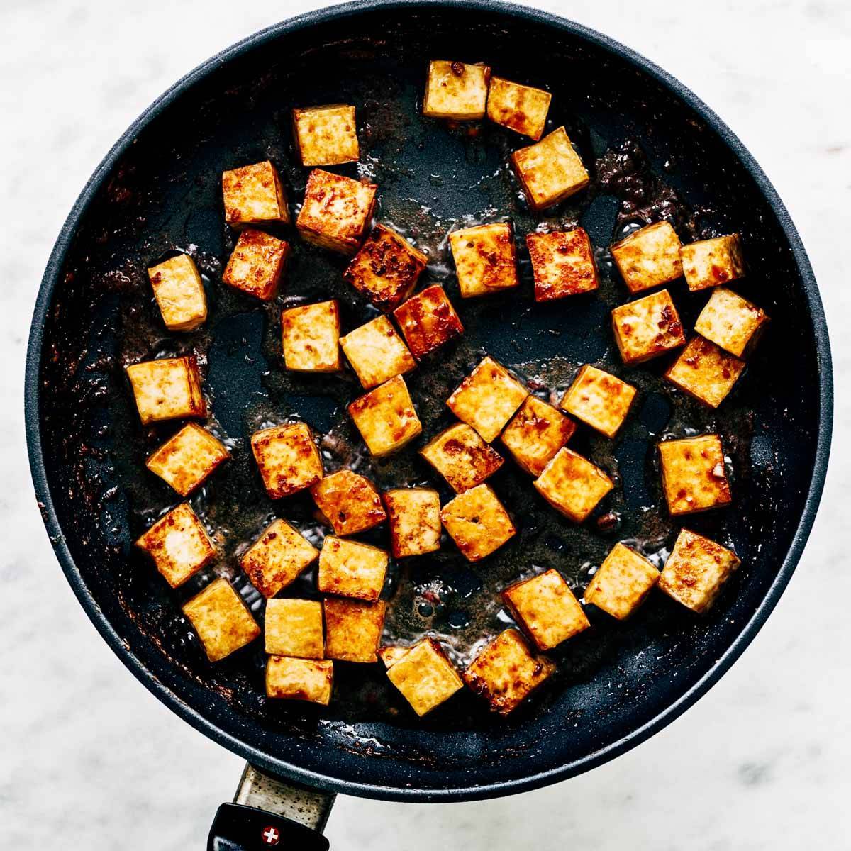 Sautèed tofu in a pan.