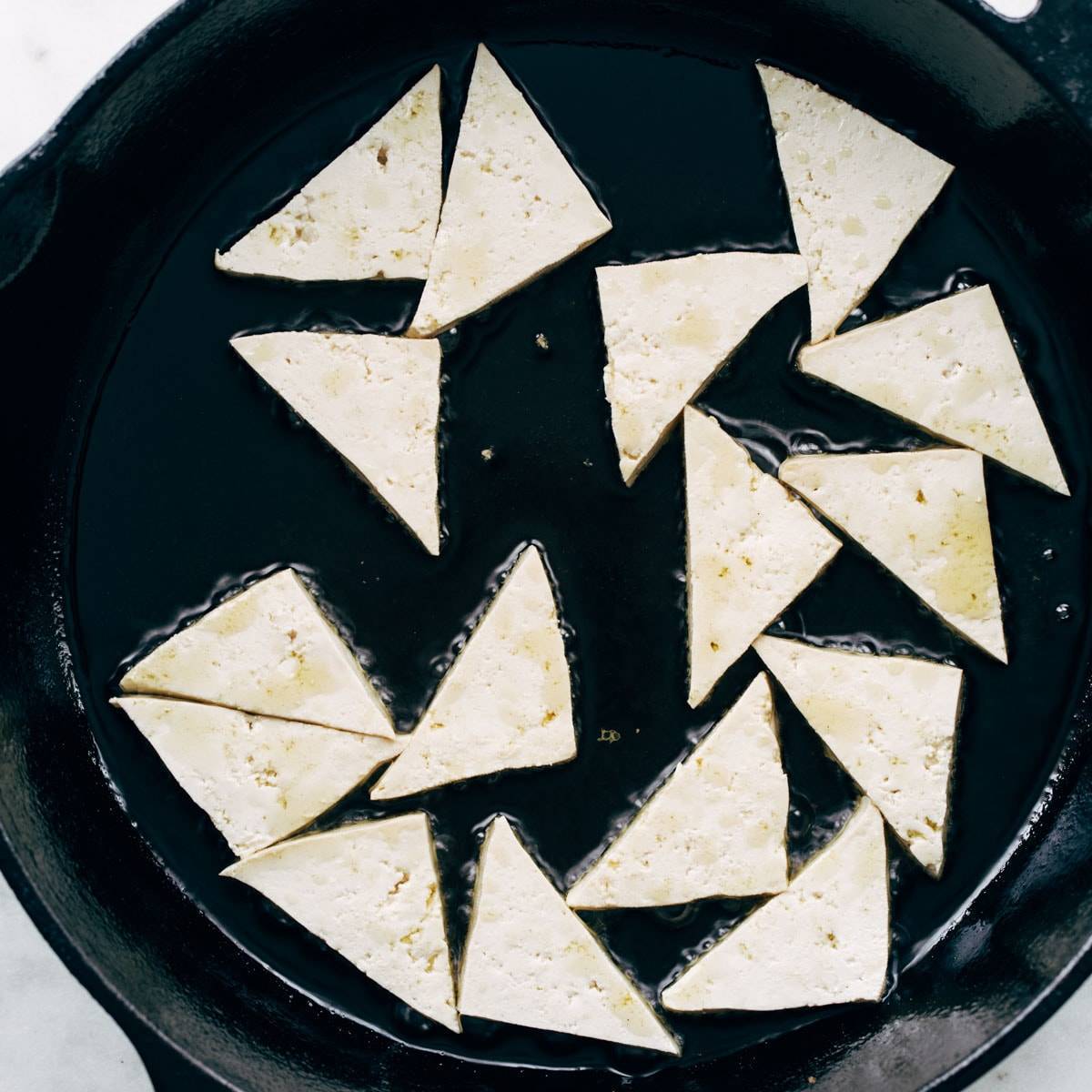 Tofu frying in a pan.