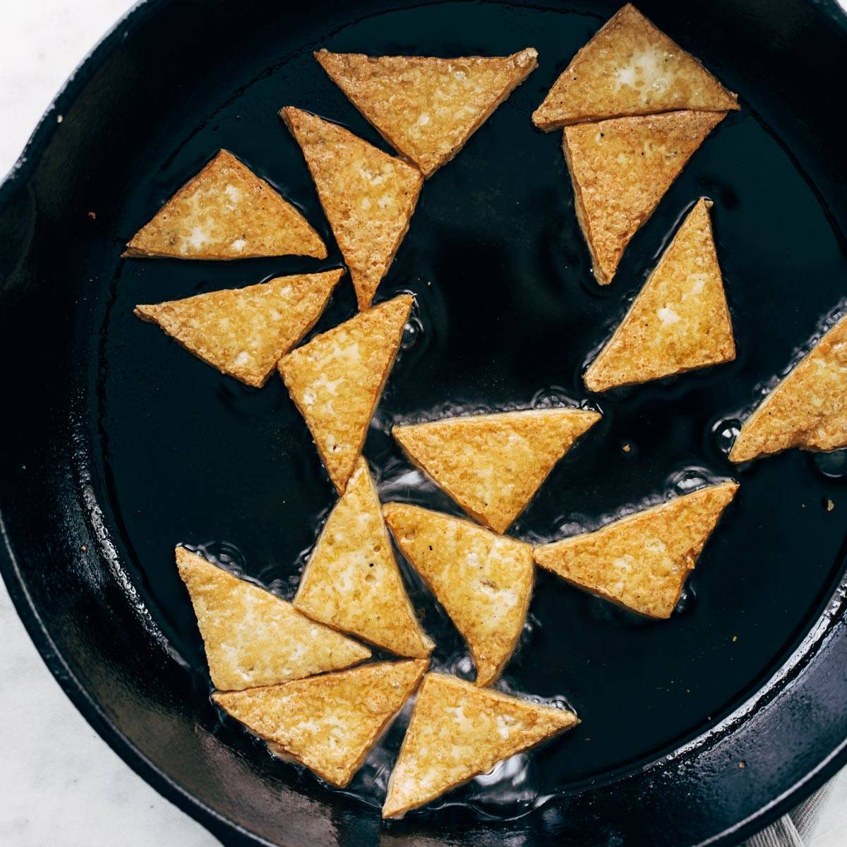 Tofu frying in a pan.