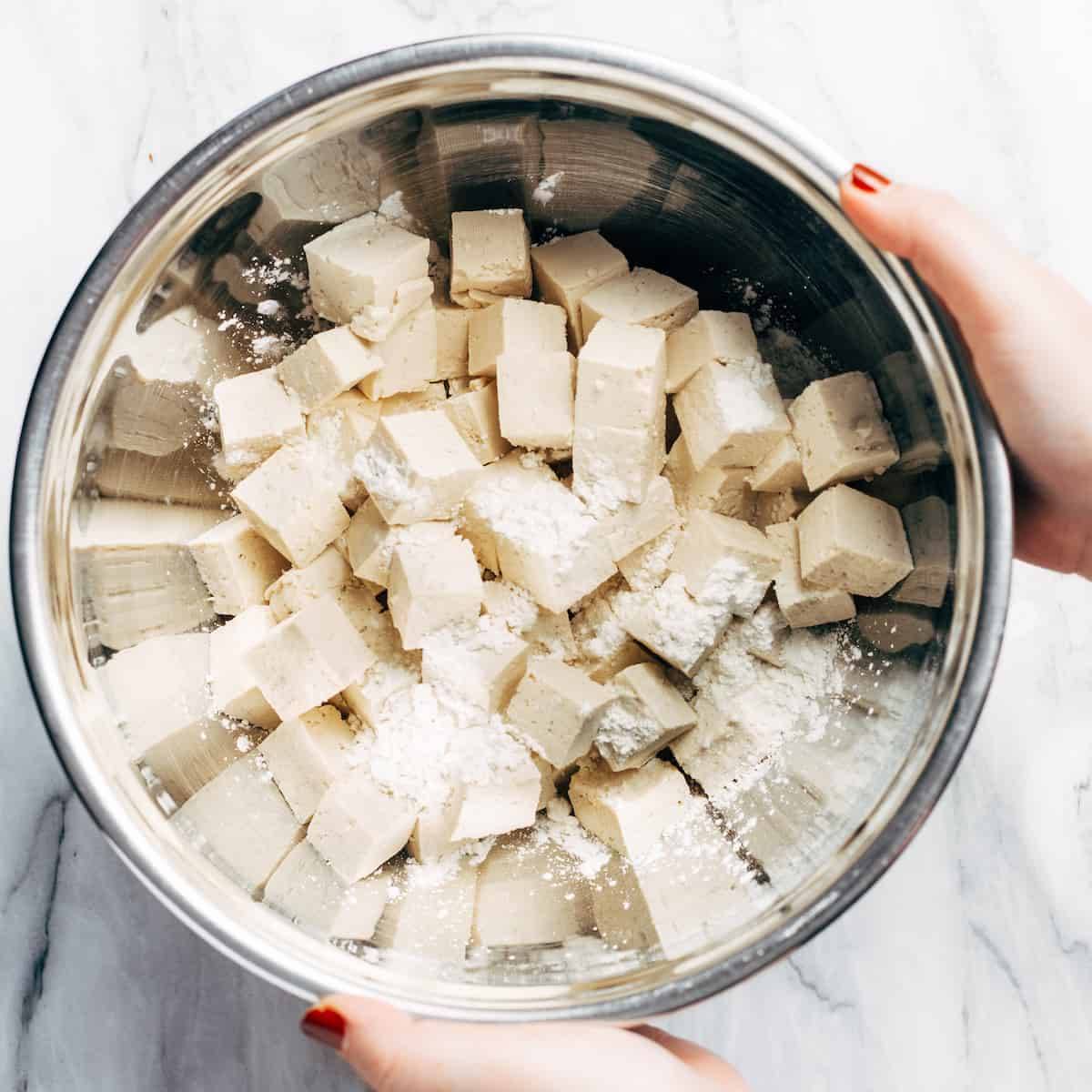 Cubed tofu in a bowl with cornstarch.