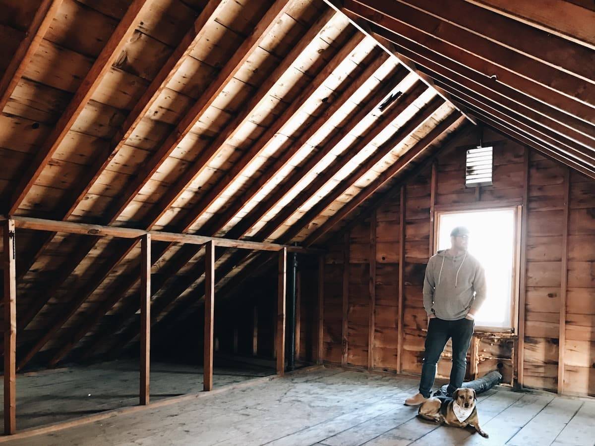 Man standing in front of a bright attic window.