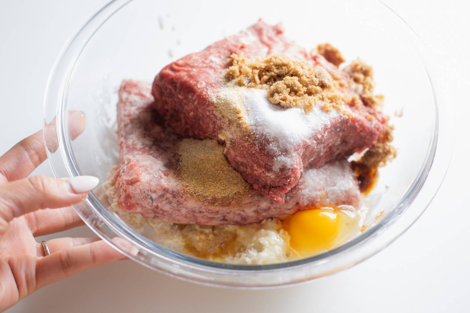 Ingredients for meatballs in a bowl before mixing.