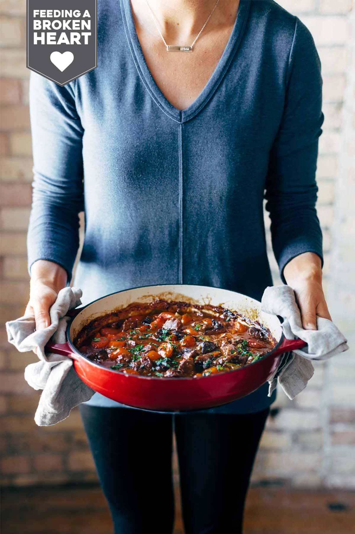 Person holding pot of beef stew.