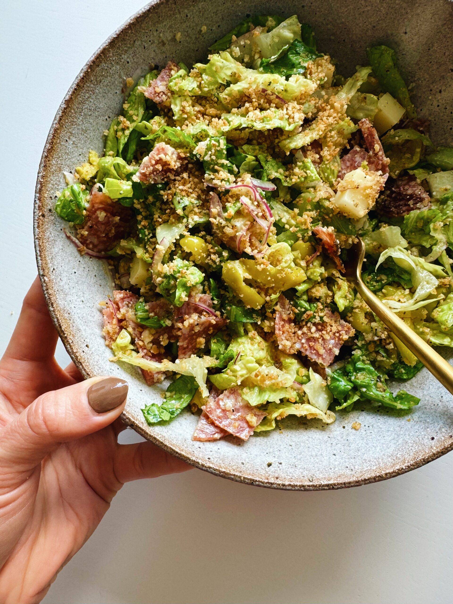 Italian salad in a bowl with breadcrumbs on top.