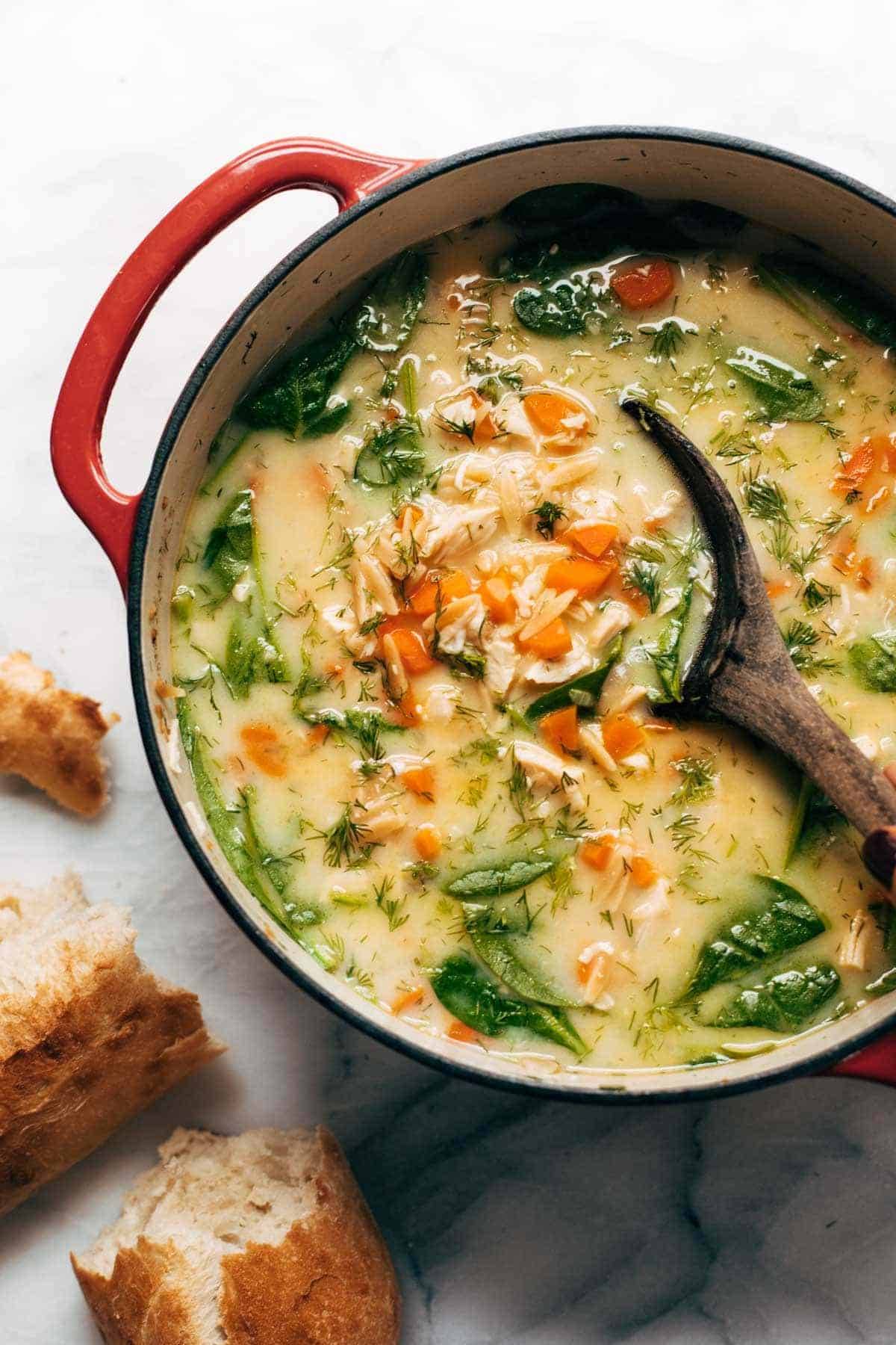 Lemon chicken soup in a pot with a spoon.