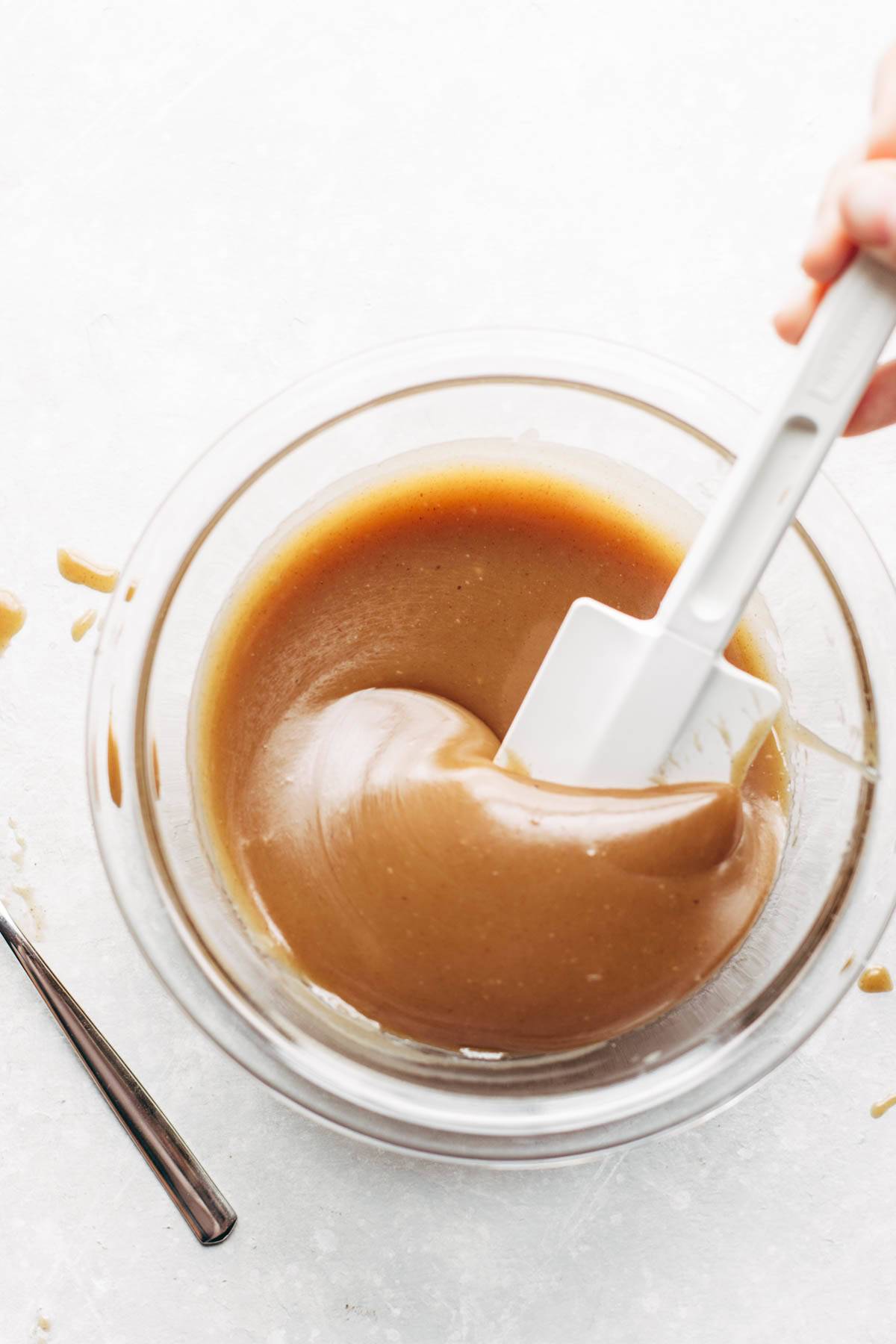 Magic Vegan Caramel Sauce made in a dish with a small spatula.