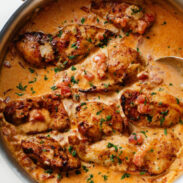 Marry Me Chicken in a pan with a spoon.