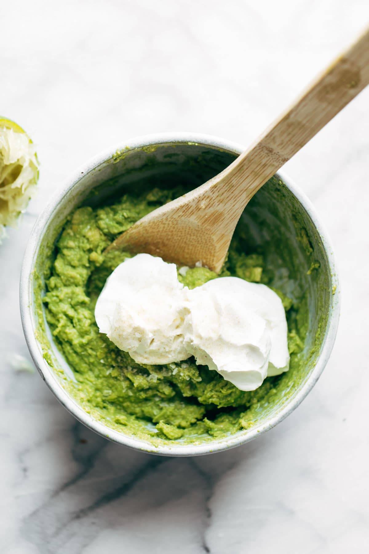 Avocado mashed in a bowl with greek yogurt.