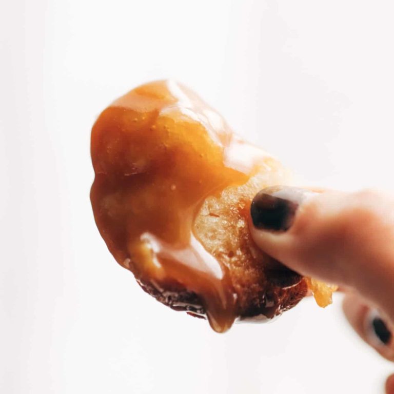 Hand holding a piece of caramel monkey bread.