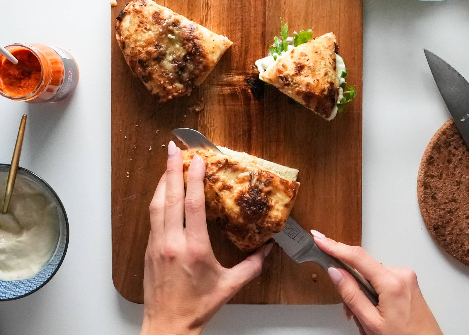 Slicing focaccia on a cutting board.