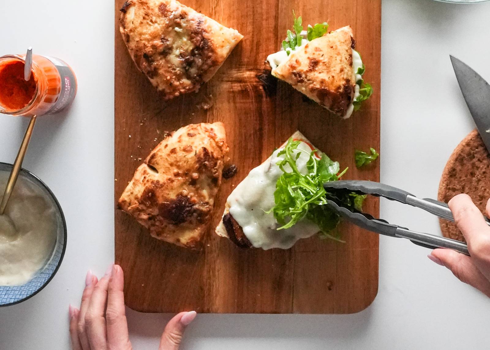 Placing arugula on a mushroom sandwich.