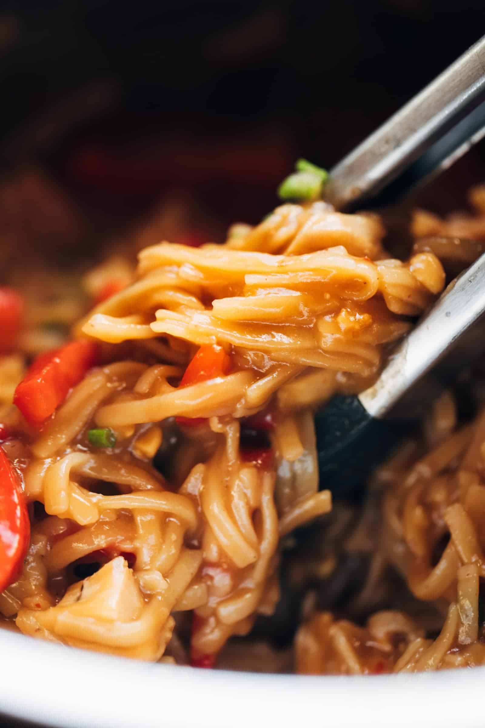 chili garlic noodles with tongs