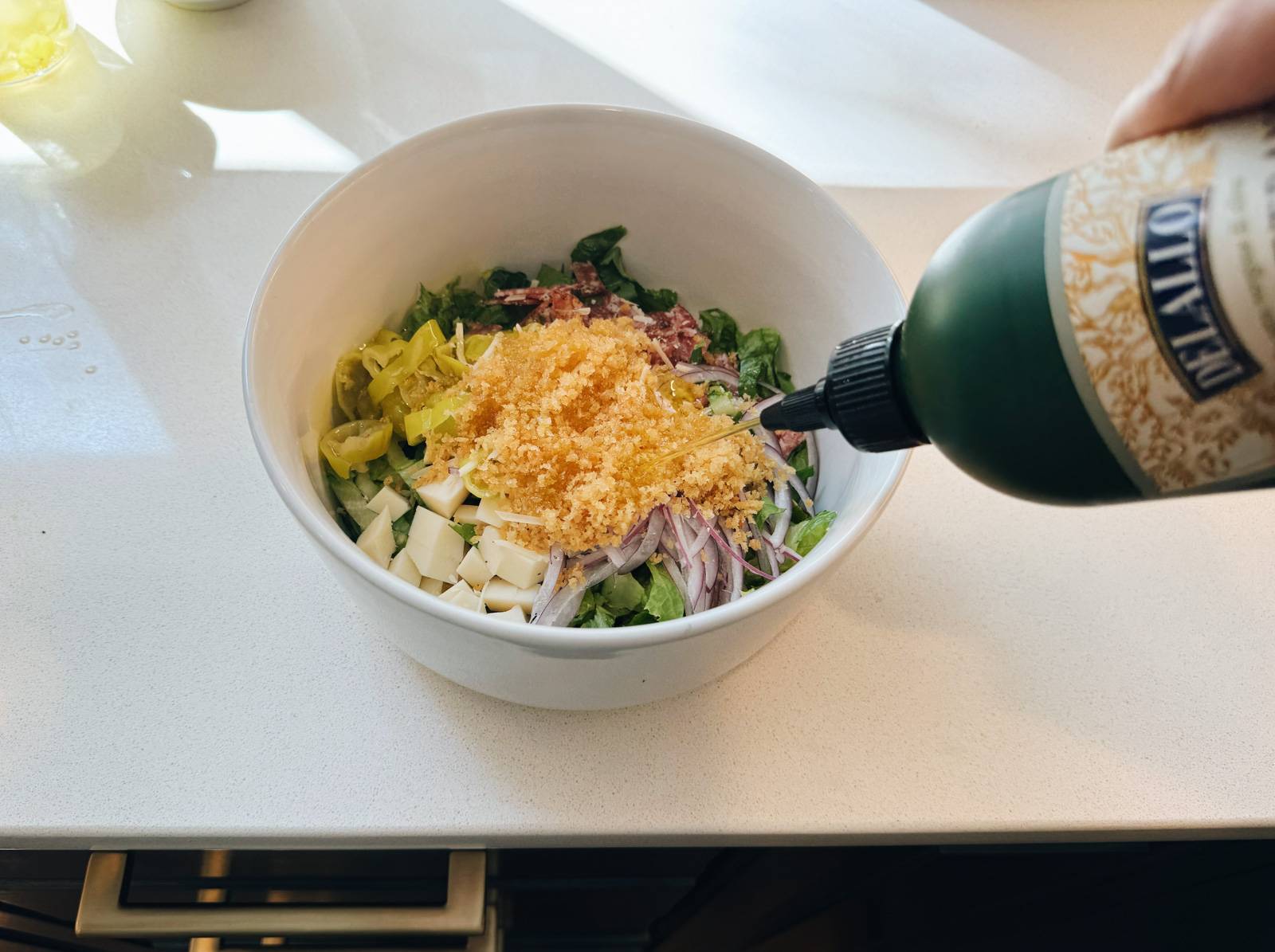 Squeezing olive oil onto a bowl of salad.