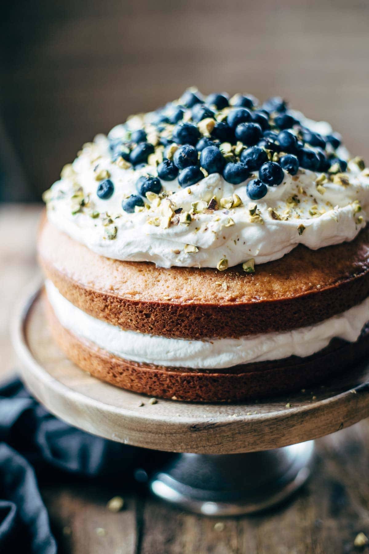 Cake on a cake stand with whipped cream.