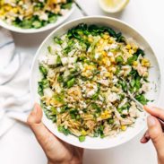 Hand holding Orzo Summer Salad in a bowl with fork.