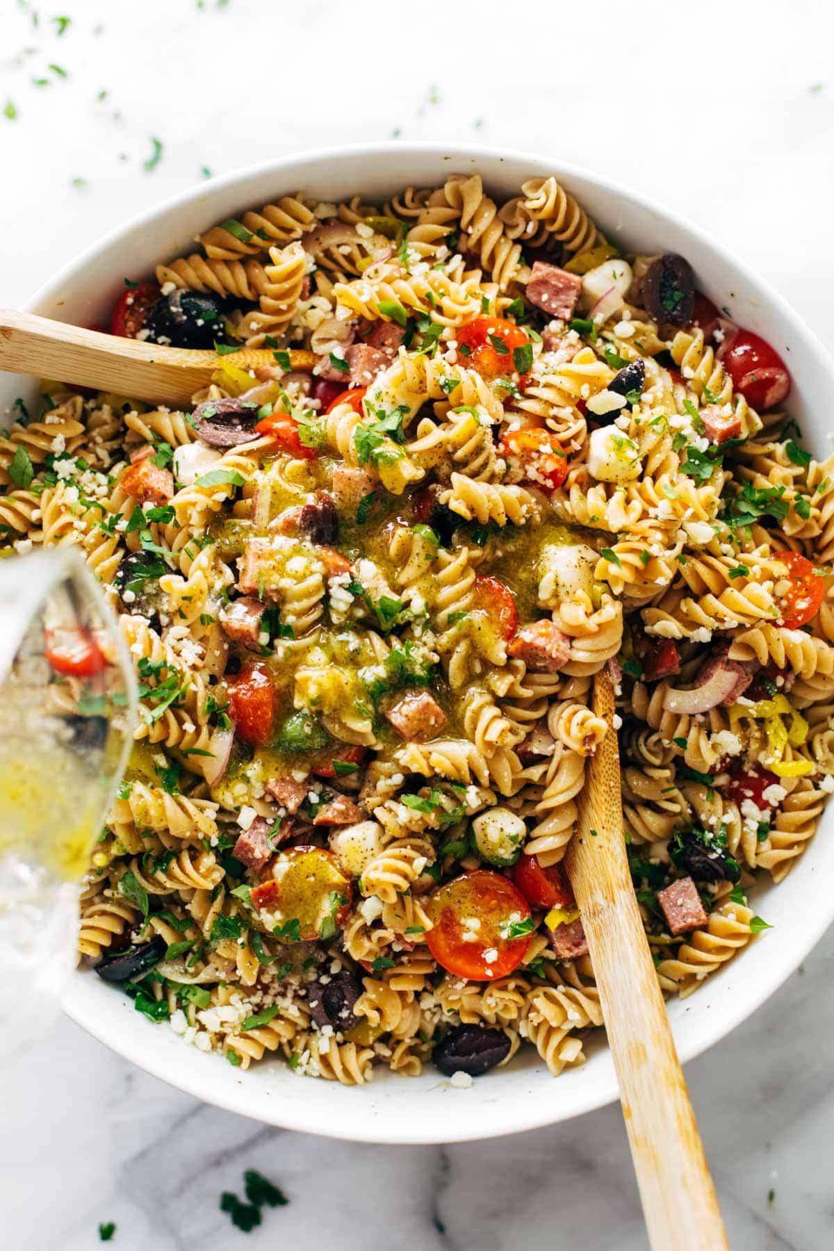 Pasta salad in bowl with spoons.