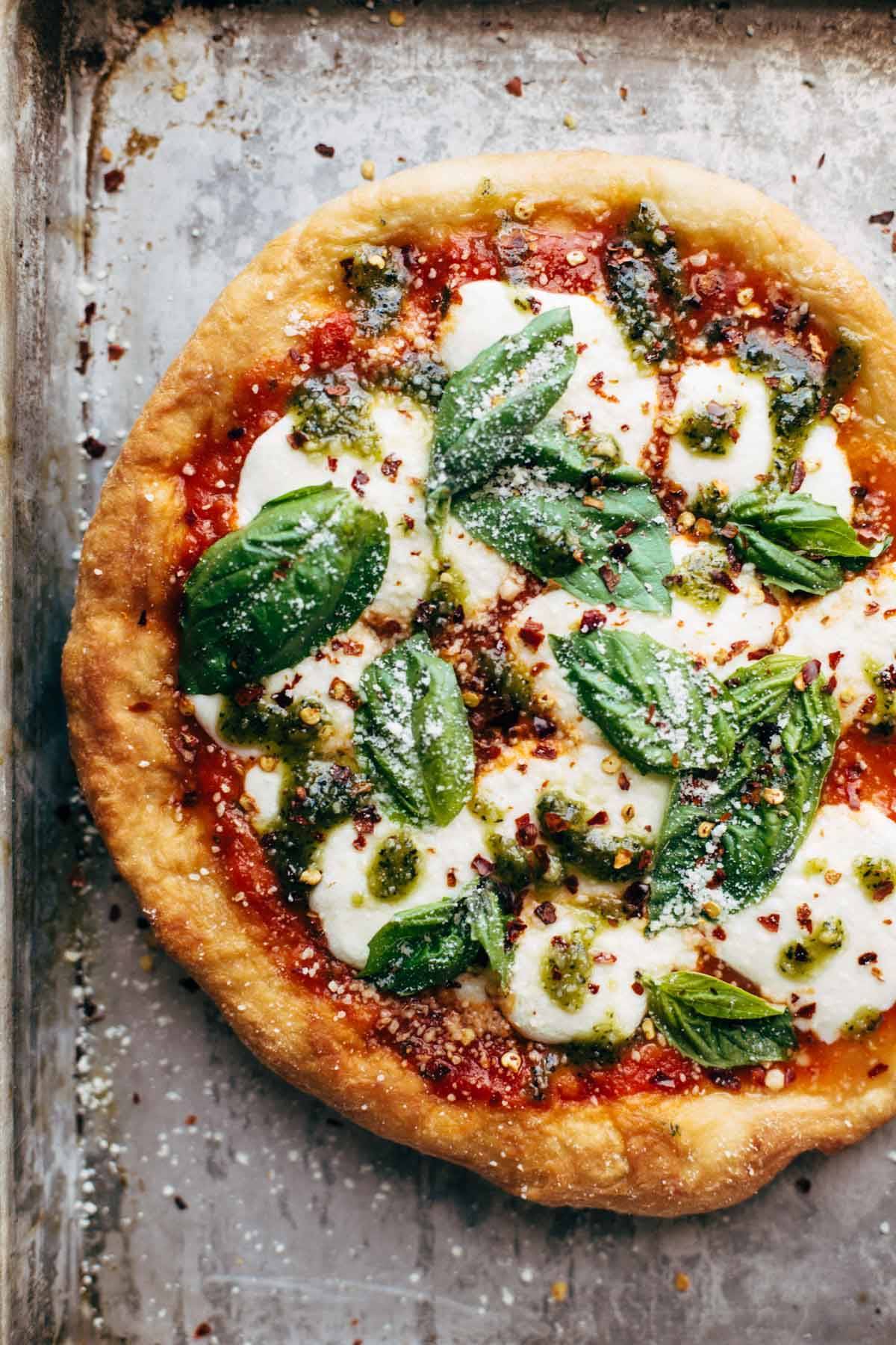 Fried Pizza with sauce, cheese, and basil on a sheet pan.