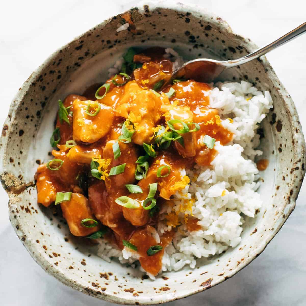 Chicken and rice in a bowl with sauce.