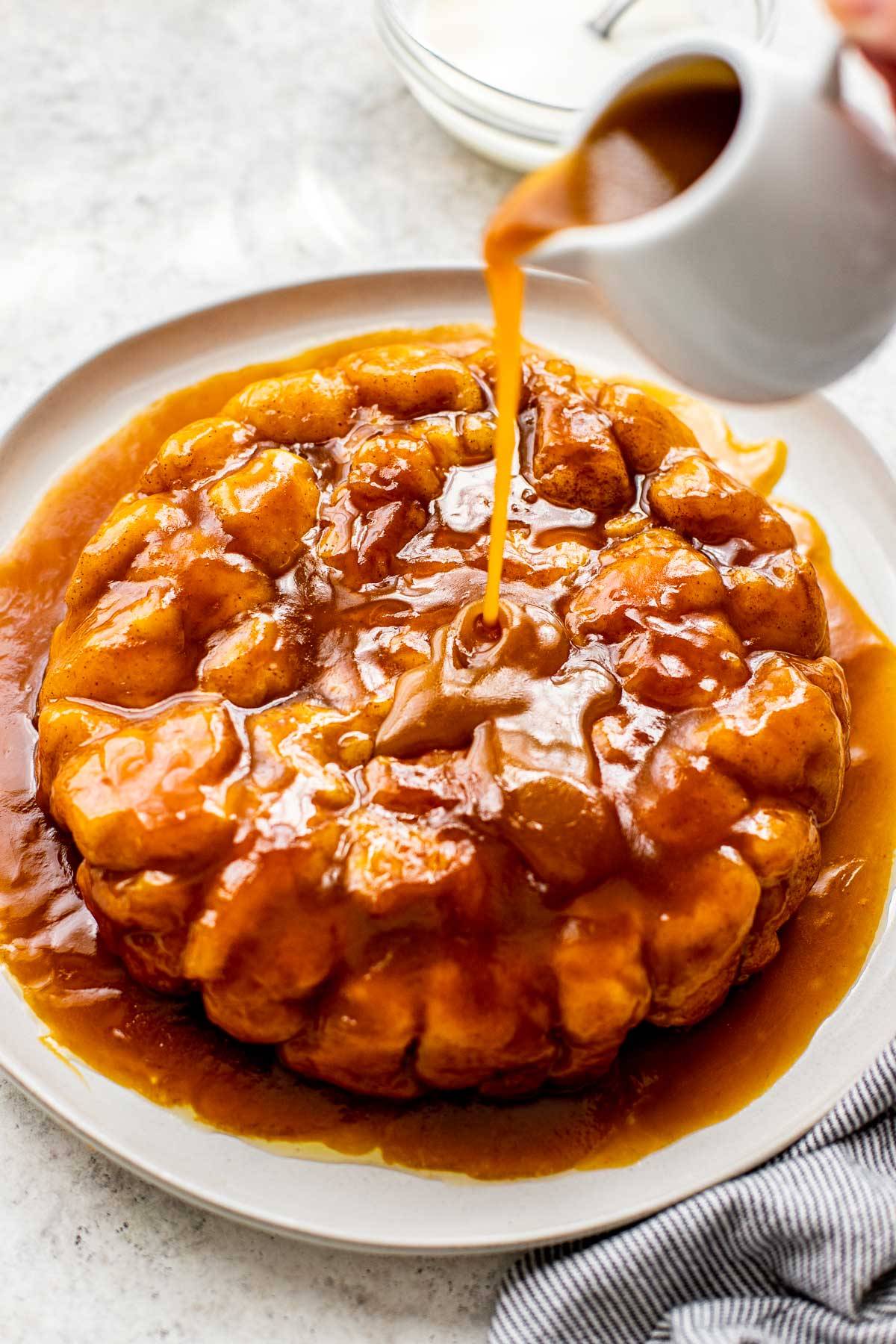 Caramel being poured on pumpkin caramel monkey bread