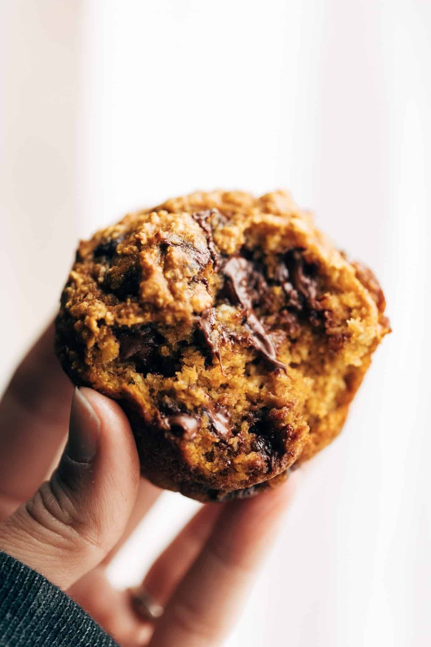 Pumpkin Muffin held in hand with bite taken out.